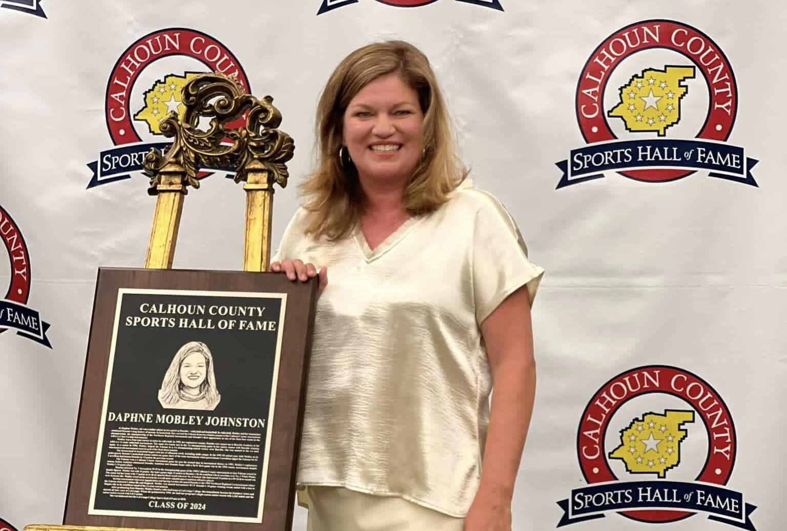 Daphne Mobley Johnston honored in Calhoun County Sports Hall of Fame Class of 2024 with plaque and smiles.