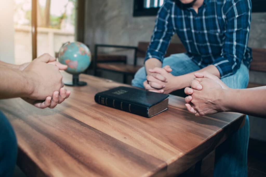 Three Christian friends praying