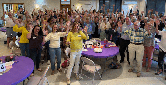 New Bern Participants and volunteers at a Respite for All event in New Bern, raising their hands and enjoying the event.