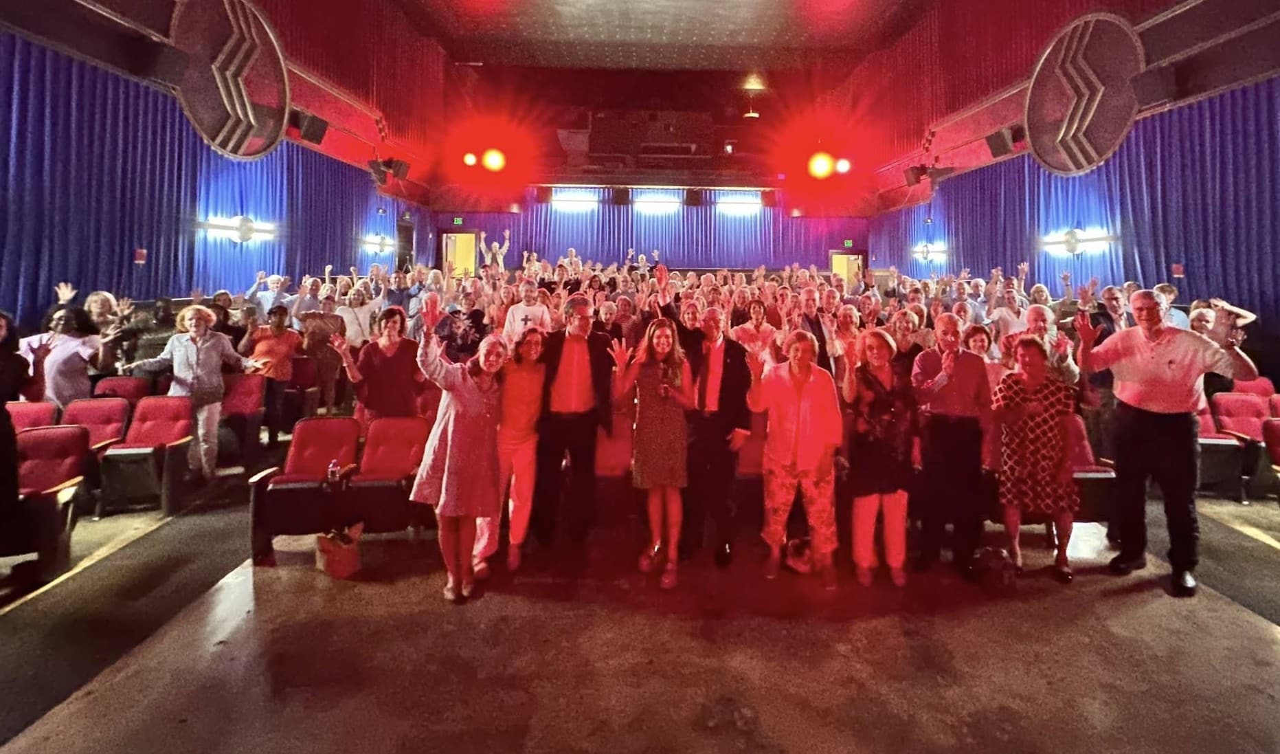 Volunteers and participants gathered at a Respite for All event in a movie theater