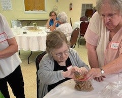 joyful connecctions A volunteer assists a participant with an activity during a special RFA event.